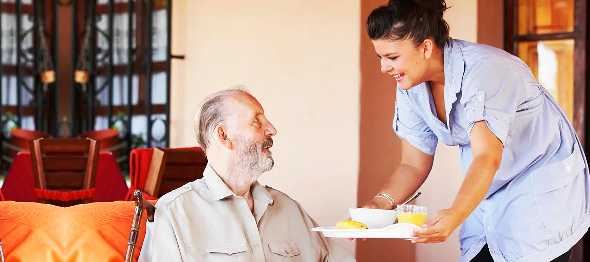 caregiver serving food to senior man