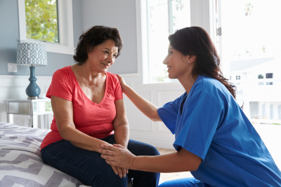 female caregiver talking to her patient while smiling