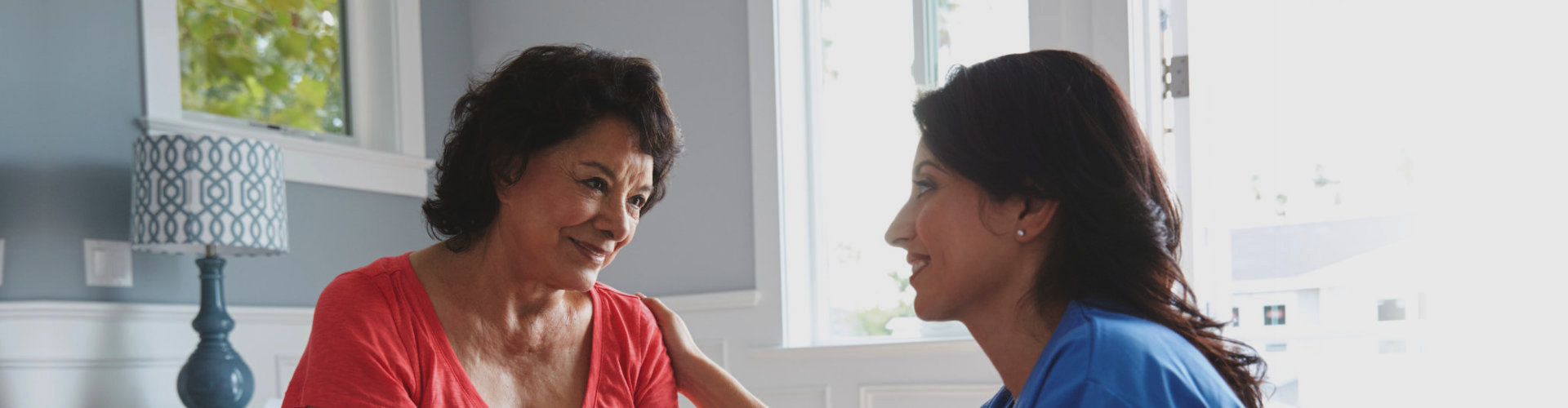 female caregiver talking to her patient while smiling
